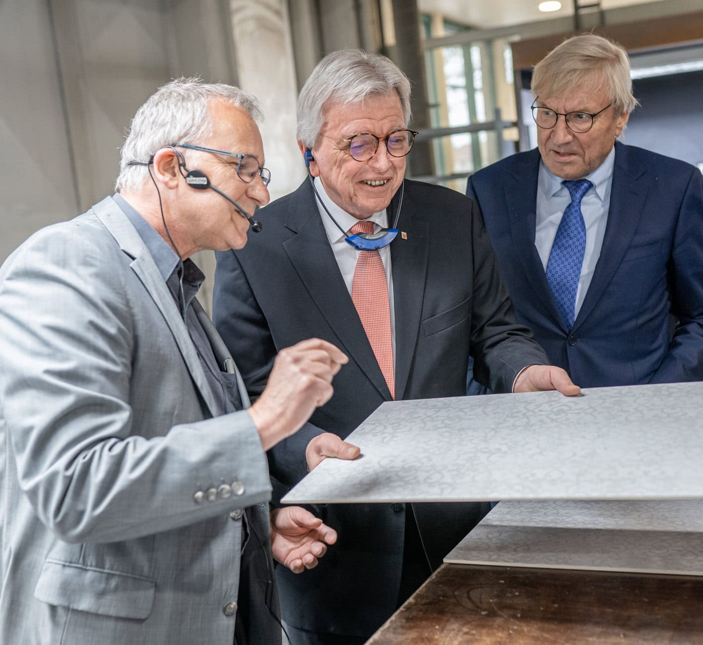 Dr. Thomas Hammer (links) überzeugt den hessischen Ministerpräsidenten Volker Bouffier (mitte) von der festen Qualität der 6 Millimeter Keramikfliese, eine Produktentwicklung mit reduziertem CO2 - Fußabdruck. Rechts: DSCB Vorstand Dieter Schäfer. Foto: deutsche-steinzeug.de/Christian Daitche