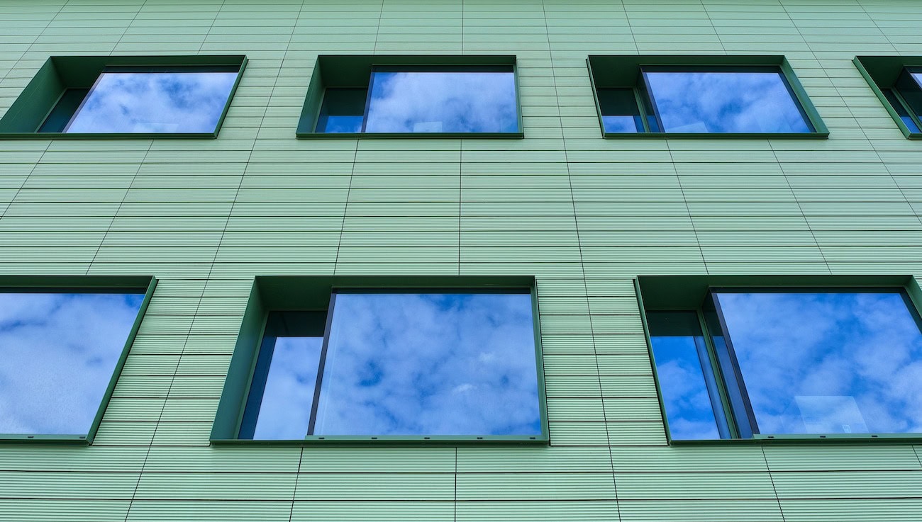 In seiner vertikalen Struktur immer wieder aufgelockert vermittelt die Farbgebung der Fassade zugleich eine optische Reduzierung des massigen Baukörpers. 