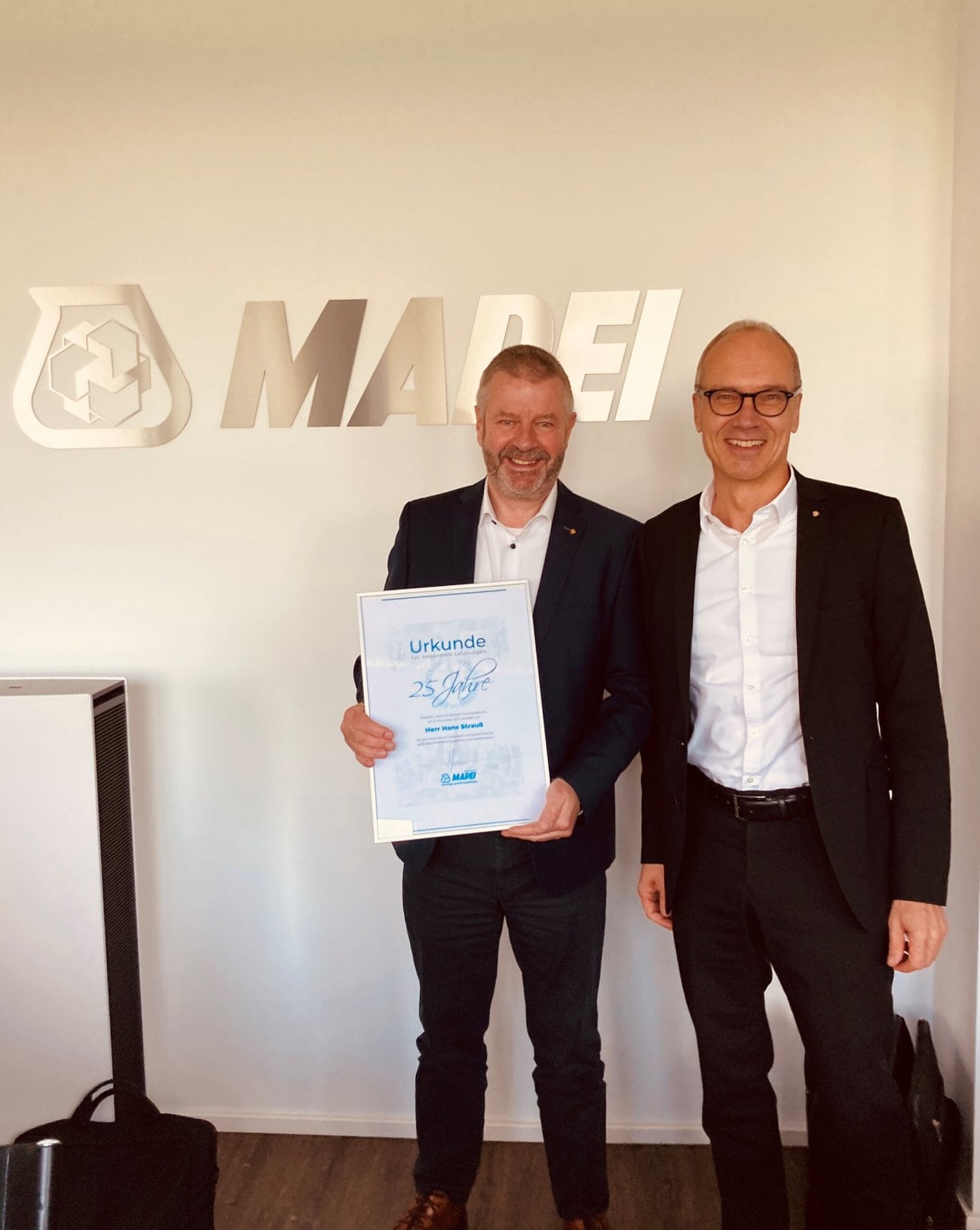Dr. Uwe Gruber, Geschäftsführer MAPEI GmbH, gratuliert Hans Strauß zu 25 erfolgreichen Jahren im Unternehmen Foto: Mapei