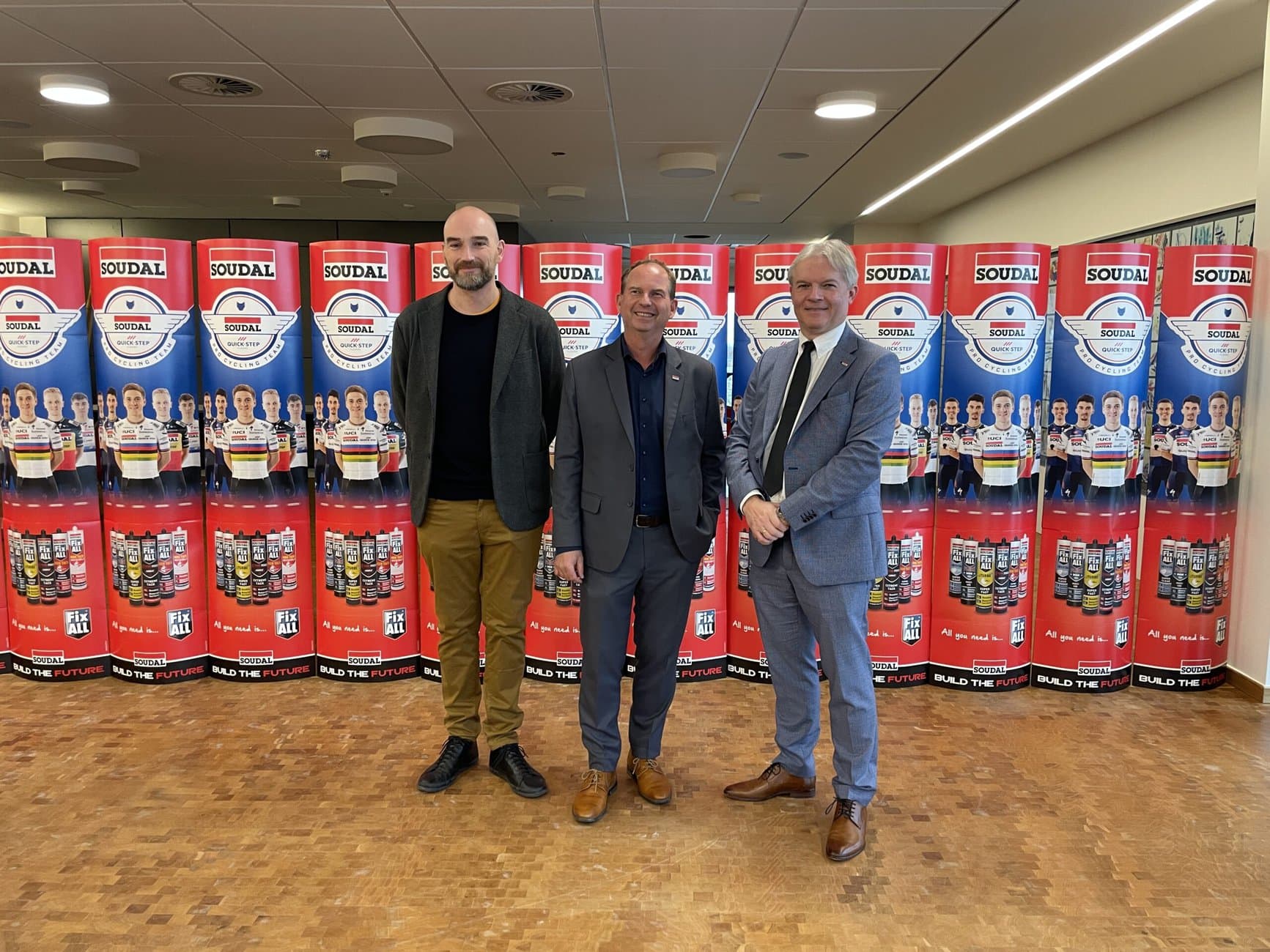 V.r.n.l.: Luc Thys, Group Director Marketing and R&D bei Soudal, Harald Lüdtke, Geschäftsführer Soudal Deutschland und Regional Director Central Europe, sowie Alexander von Vulté, Leitung Marketing und Technischer Service Soudal Deutschland vor einer Wand aus Verkaufsständern. Soudal wirbt schon seit Jahren mit professionelle Rennrad-Teams für seine Produkte am POS. Alle Fotos: Redaktion