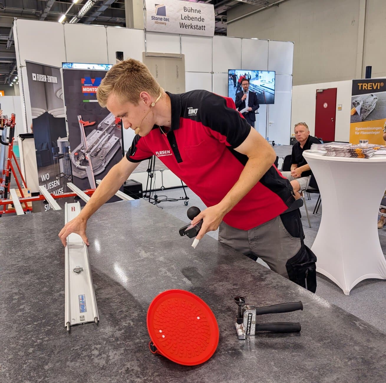 Live-Demonstration auf der Messebühne: Sandro Feustel von Deutschland Fliesen-Nationalmannschaft bearbeitete mit dem neuesten Werkzeug eine secsh Millimeter dünne XXL-Feinsteinzeugfliese.