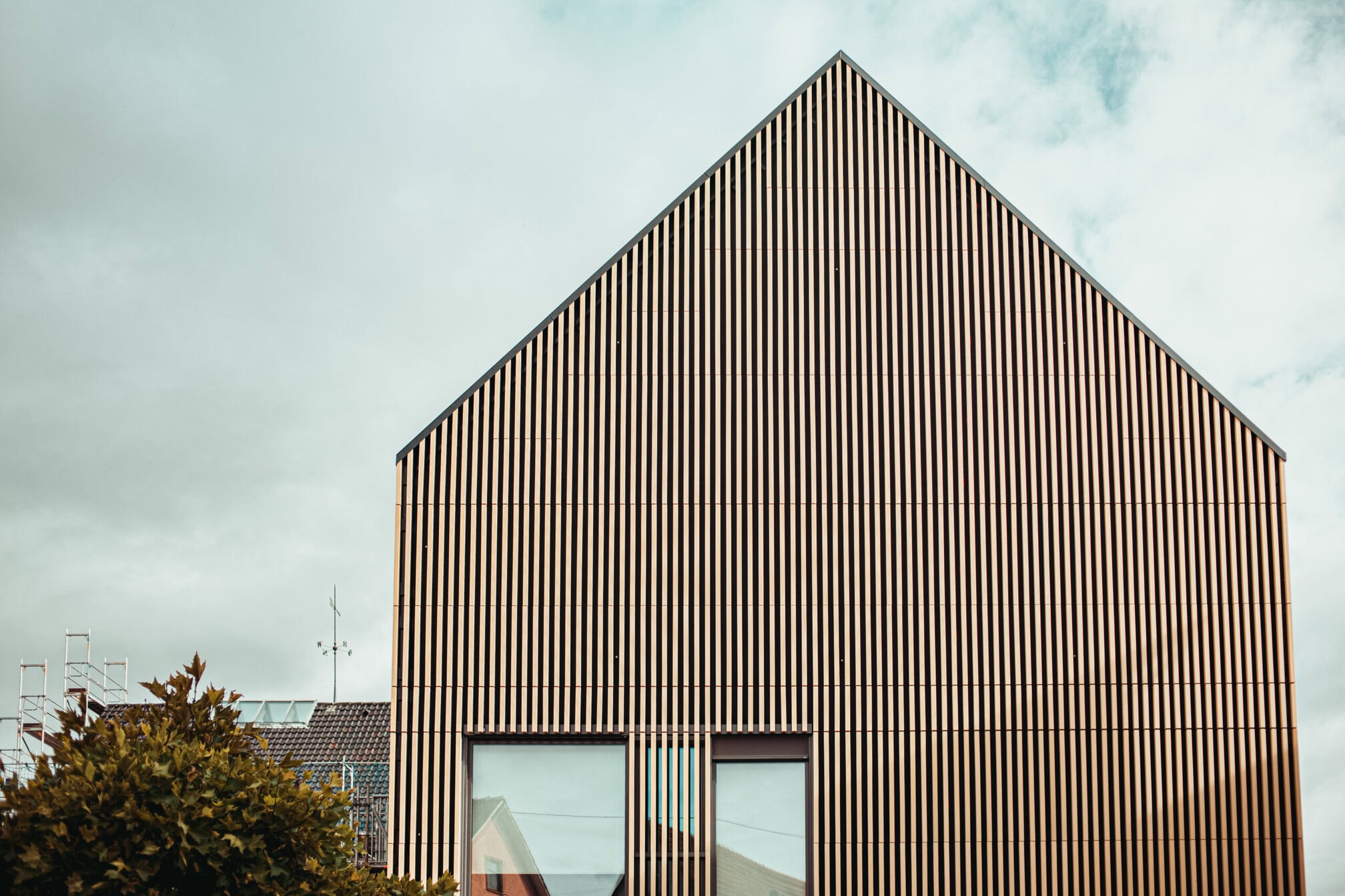 Die Giebelseite des Neubaus wurde komplett mit keramischen Baguettes gestaltet. Dies lockert die Fassade nochmals auf und sorgt dafür, dass der Neubau nicht wie ein bewegungsloser Fremdkörper wirkt.Print: Fotos: buero-magma.com