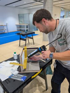 Die finale Challenge: Fugen-Champion Christian Ullmann beim Verarbeiten des Hybrid-Dichtstoffes Ottoseal M 361 auf dem Fliesensockel. Bei der Arbeit zog er alle anderen Teilnehmer ab wie seine Fugen.