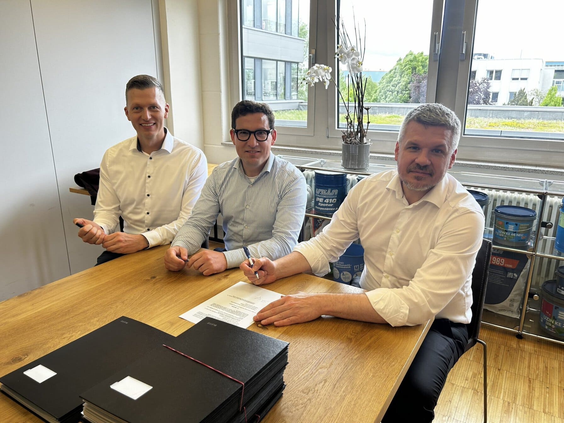 Christian Richter (Mitglied des Vorstands), Julian Utz (Mitglied des Vorstands) und Haiko Stüting (Managing Partner von SOL Capital) markieren mit der Vertragsunterzeichnung den strategischen Ausbau des Uzin Utz Portfolios.